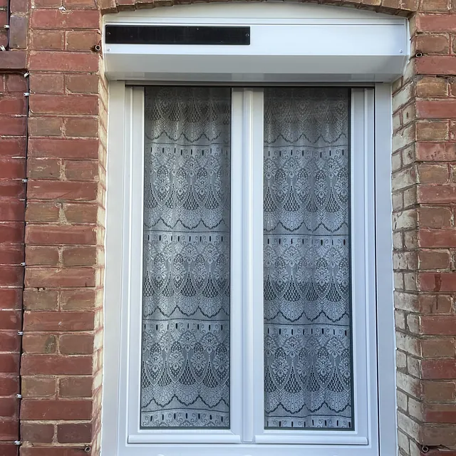 Fenêtre en PVC blanc avec volet roulant solaire intégré.